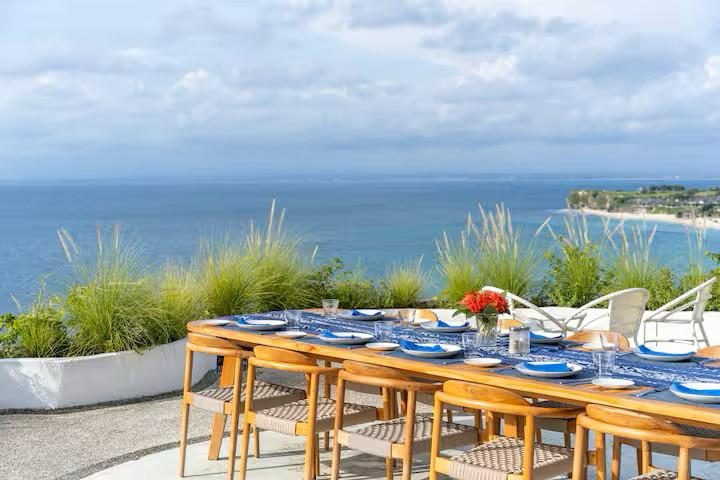A long table set above the ocean, ready for guests
